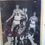 Black and white photograph of vintage basketball game with players in numbered jerseys competing for the ball