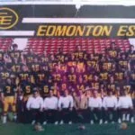 Edmonton Eskimos football team posed for squad photo on field with red stadium seating in background