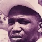Man wearing a light-colored cowboy hat, close-up portrait in purple-tinted photograph