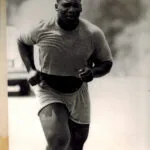 Man jogging outdoors in t-shirt and shorts, black and white photograph